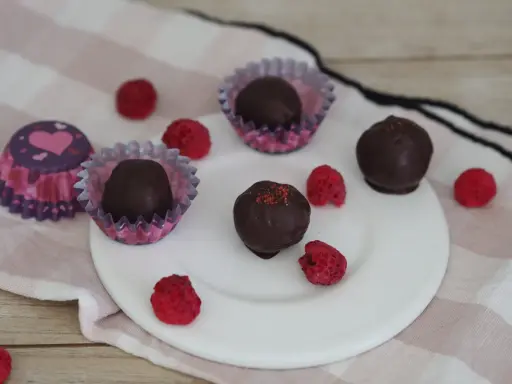 Schoko energy balls mit Himbeeren und Herz-förmigen Pralinenförmchen.