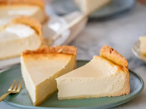 Zwei cremige Käsekuchenstücke auf einem grünen Teller, bereit zum Genießen. Perfekt für Ihre nächsten Kuchen Rezepte.