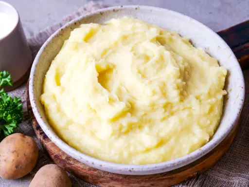 Cremiger Kartoffelbrei, perfekt für jedes Kartoffelbrei Rezept. Mit frischer Petersilie und Milch daneben.