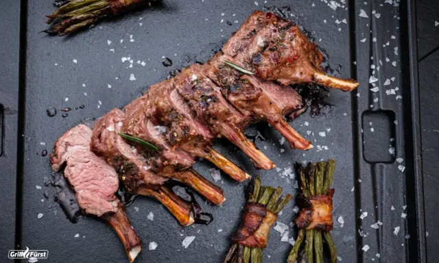 Ein perfekt gegrilltes Lammkarree mit Rosmarin und Speckbohnen. Das ganze Lamm grillen ist eine Kunst, die hier meisterhaft präsentiert wird.