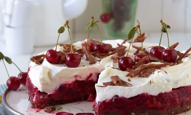 Ein saftiger Kirsch Sahne Kuchen mit frischen Kirschen und Schokostreuseln, bereit zum Genießen.
