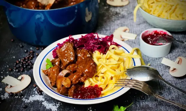 Herzhaftes Rehgulasch mit Spätzle, Rotkohl und Preiselbeeren. Ein köstliches Rehgulasch Rezept für Genießer.