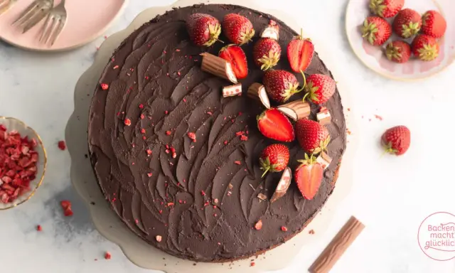 Schokoladige Yogurette Torte mit frischen Erdbeeren und Schokoriegel-Stücken verziert. Ein Traum für jeden Kuchenliebhaber!