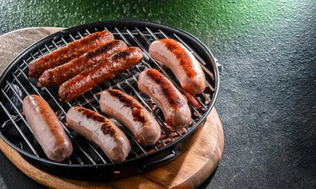 Saftige Bratwürste brutzeln auf einem Grill. Perfekt für leckere Bratwurst Rezepte, die jeden Gaumen erfreuen.