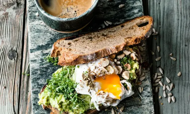 Herzhaftes Avocado-Toast mit pochiertem Ei und Kresse. Ein warmes Frühstück, das Lust auf mehr macht.