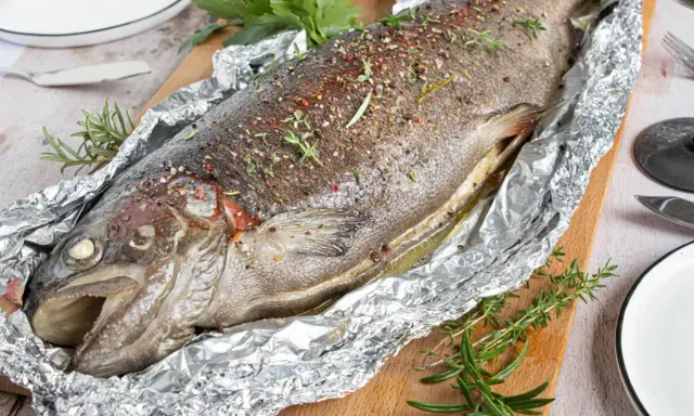 Saftige Lachsforelle im Backofen, mit Kräutern und Gewürzen verfeinert, bereit zum Servieren.