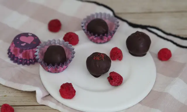 Schoko energy balls mit Himbeeren und Herz-förmigen Pralinenförmchen.