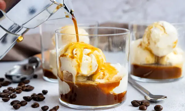 Heißer Kaffee fließt in ein Glas mit cremigem Vanilleeis. Ein köstlicher Affogato, perfekt für eine süße Erfrischung.