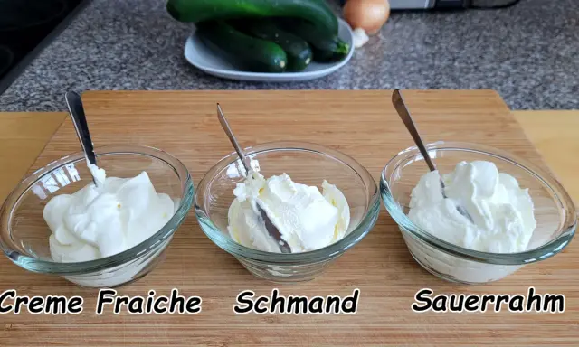 Drei Schüsseln mit cremigem Frischkäse: Crème Fraîche, Schmand und Sauerrahm. Perfekt für deutsche Rezepte.