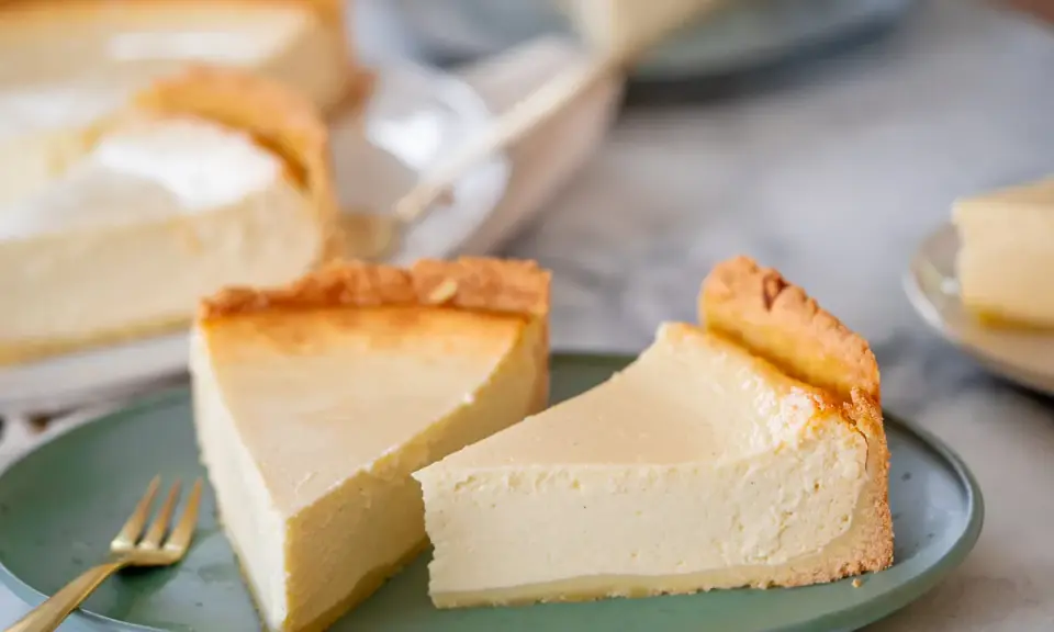 Zwei cremige Käsekuchenstücke auf einem grünen Teller, bereit zum Genießen. Perfekt für Ihre nächsten Kuchen Rezepte.