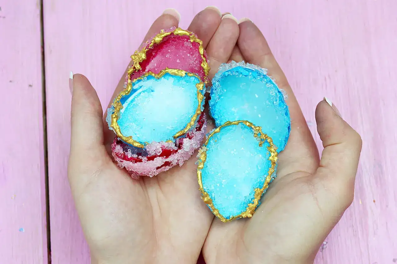 H&auml;nde halten bunte, essbare Kristalle, die wie Geoden aussehen. Ein DIY-Projekt, um essbare Kristalle selber zu machen.