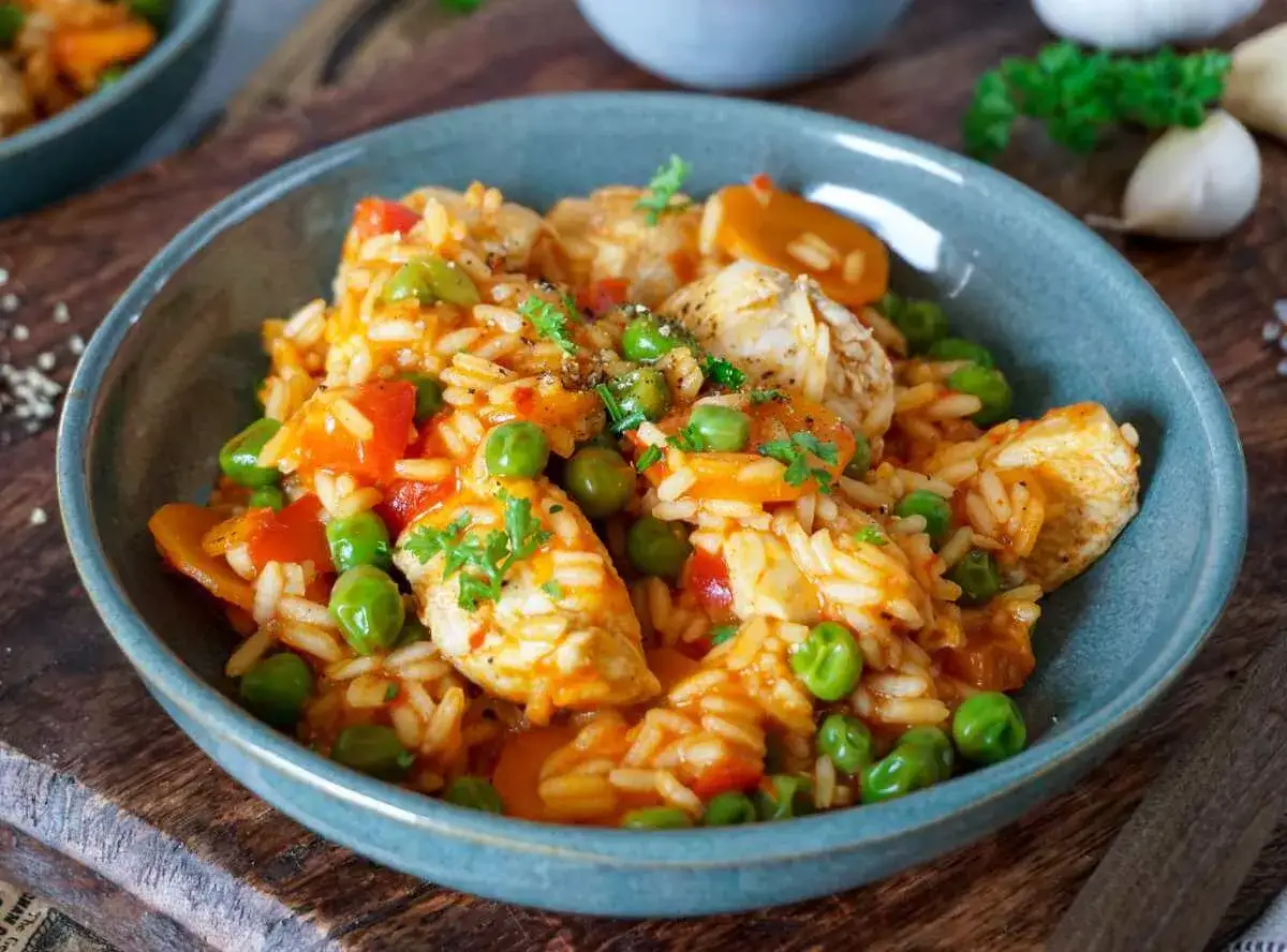 Serbisches Reisfleisch mit Erbsen und Karotten in einer w&uuml;rzigen Tomatensauce, garniert mit Petersilie.