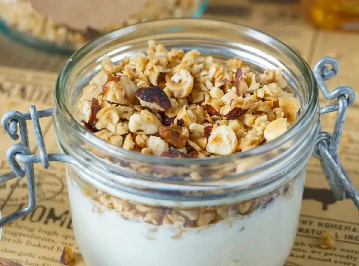 Leckeres Joghurt-Parfait mit selbstgemachtem Crunch aus Nüssen und Haferflocken im Glas.