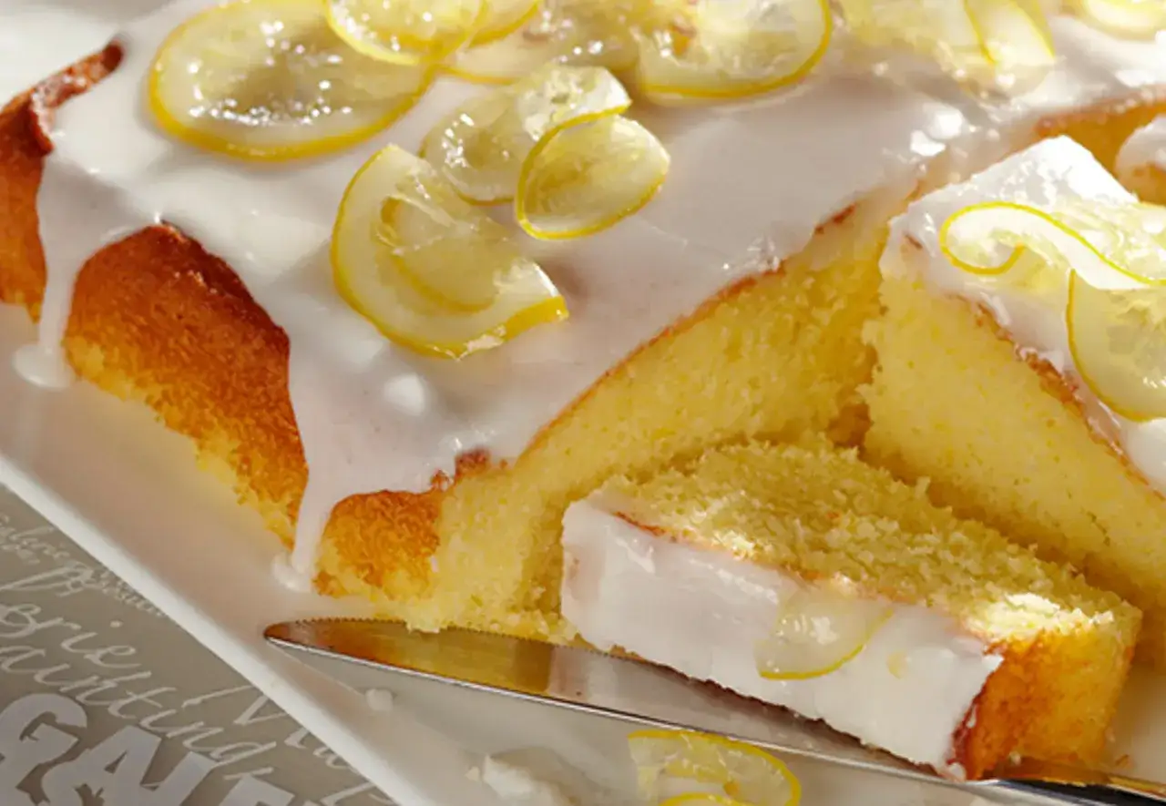 Saftiger Zitronenkuchen mit zuckerguss und kandierten Zitronenscheiben. Perfekt für warme oder kalte Tage.