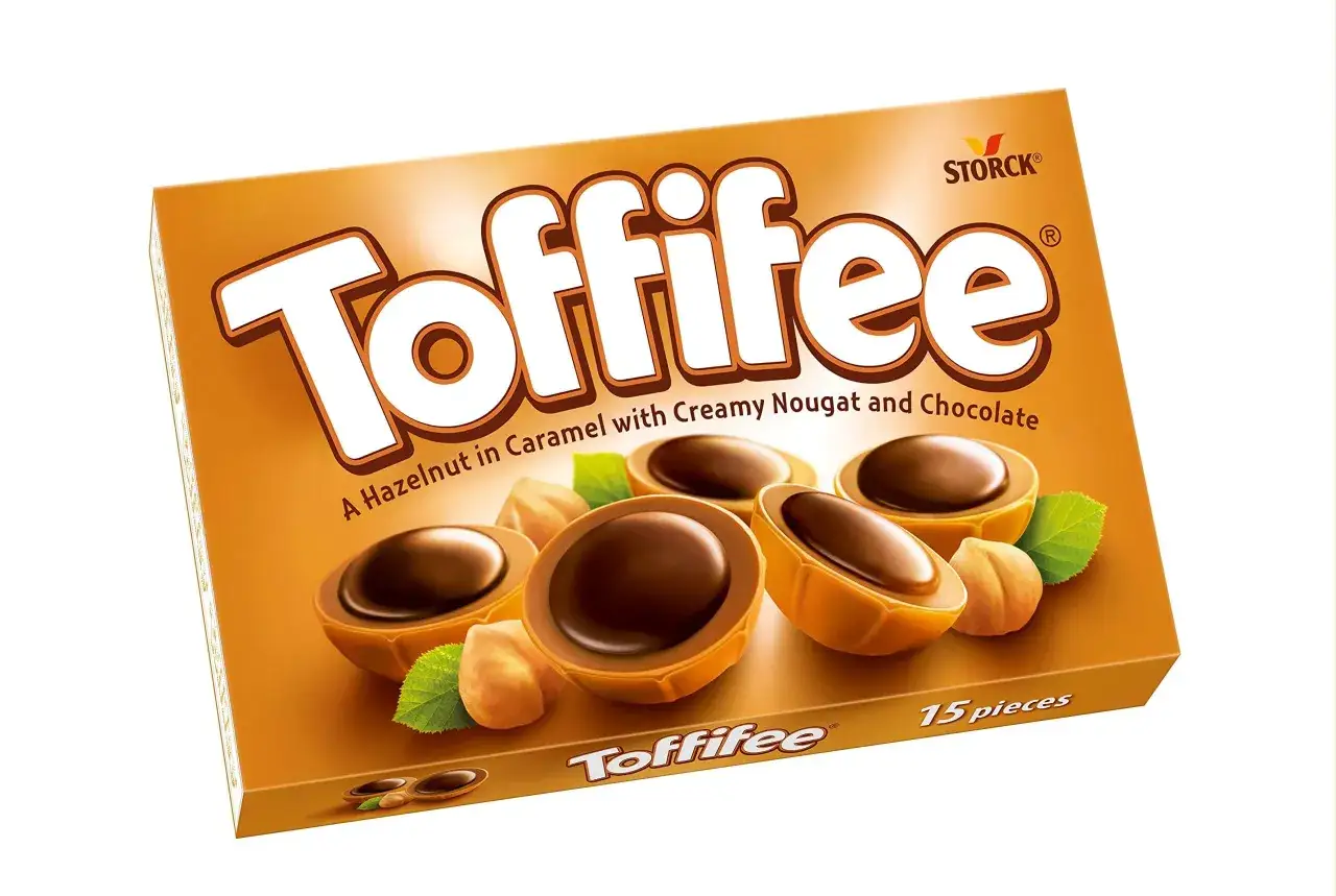 Eine Packung Toffifee mit vier halbierten Pralinen, Haseln&uuml;ssen und Bl&auml;ttern. Perfekt f&uuml;r den Toffifee Kuchen!