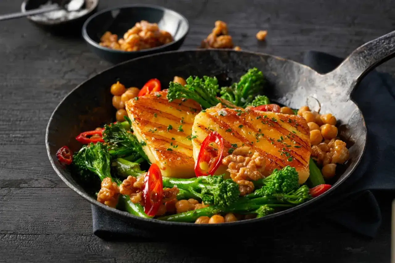 Gebratener Brokkoli mit Kichererbsen, Waln&uuml;ssen und gegrilltem Halloumi in einer Pfanne.