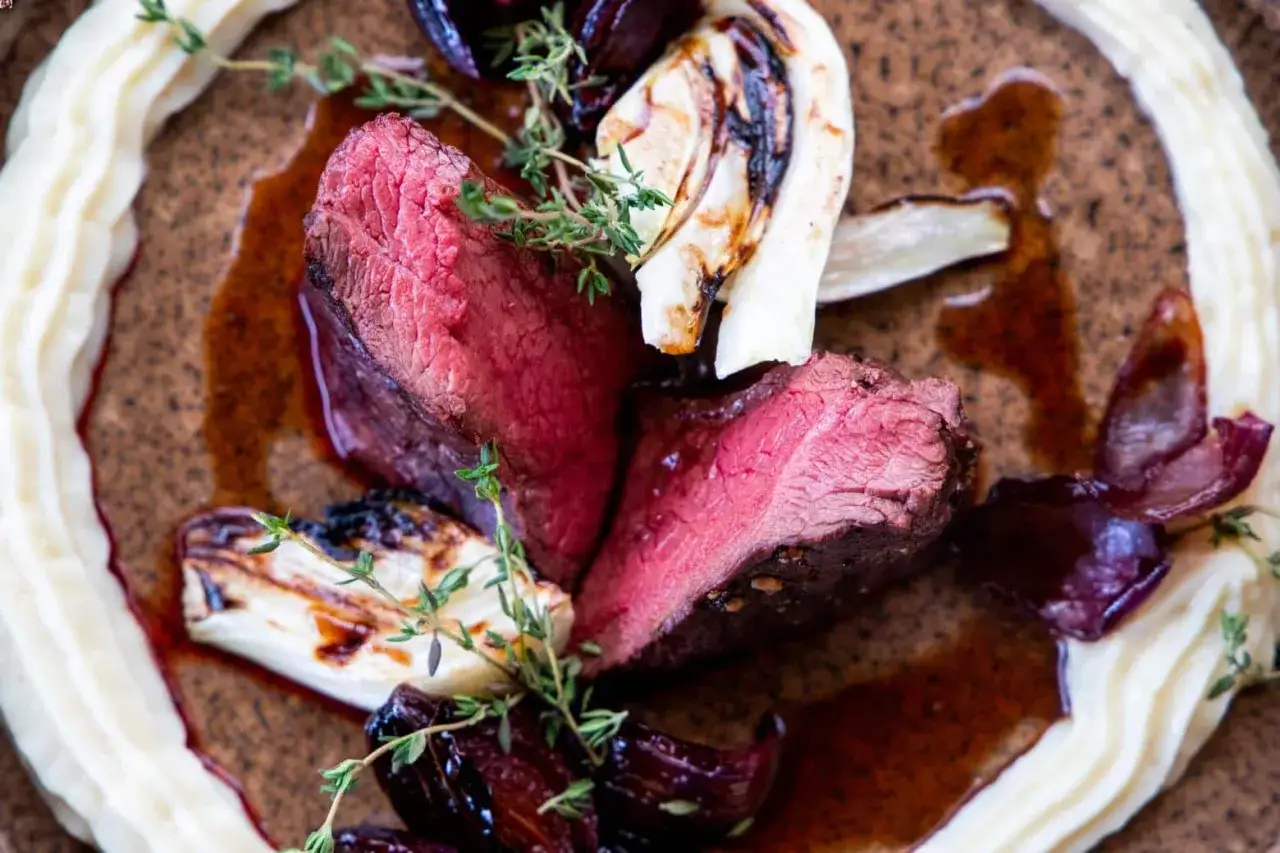 Perfekt gegartes Hirschsteak mit cremigem P&uuml;ree, karamellisierten Zwiebeln und Fenchel. So gelingt das Hirschsteak richtig braten!