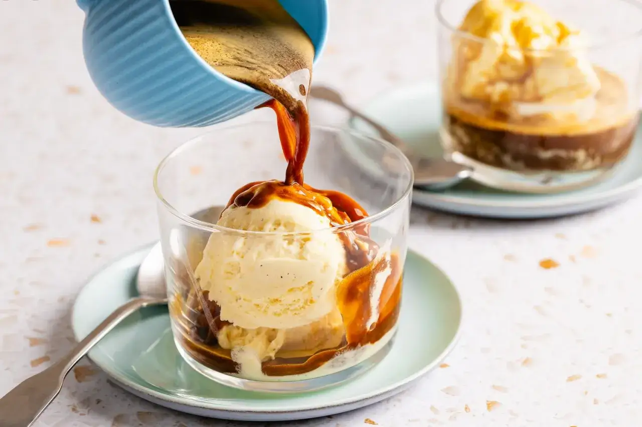 Heißer Espresso fließt über cremiges Vanilleeis. Ein köstlicher Affogato cafe, der zum Genießen einlädt.