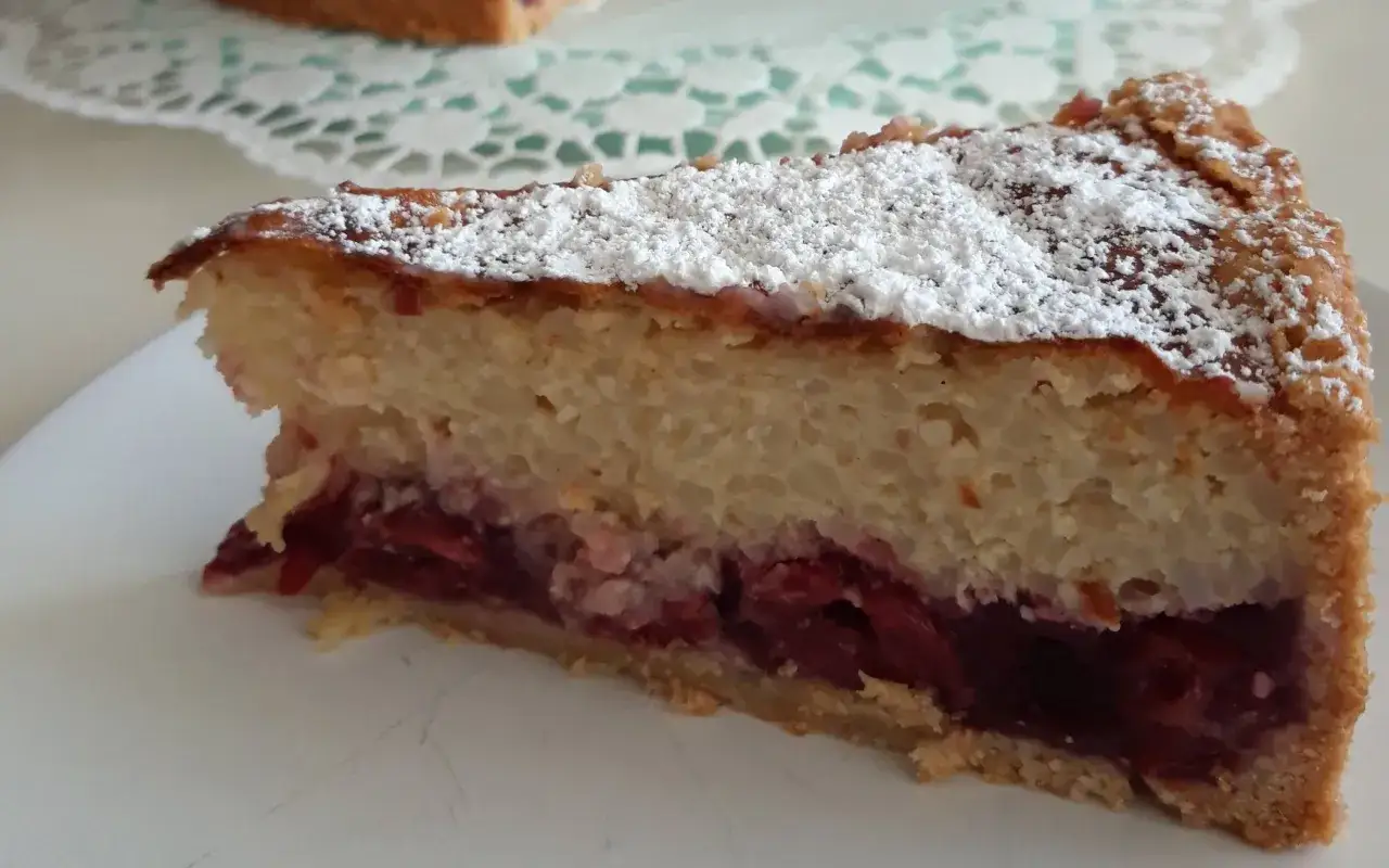 Ein St&uuml;ck Kirsch-Milchreiskuchen, best&auml;ubt mit Puderzucker. Ein k&ouml;stliches milchreiskuchen rezept f&uuml;r jeden Anlass.