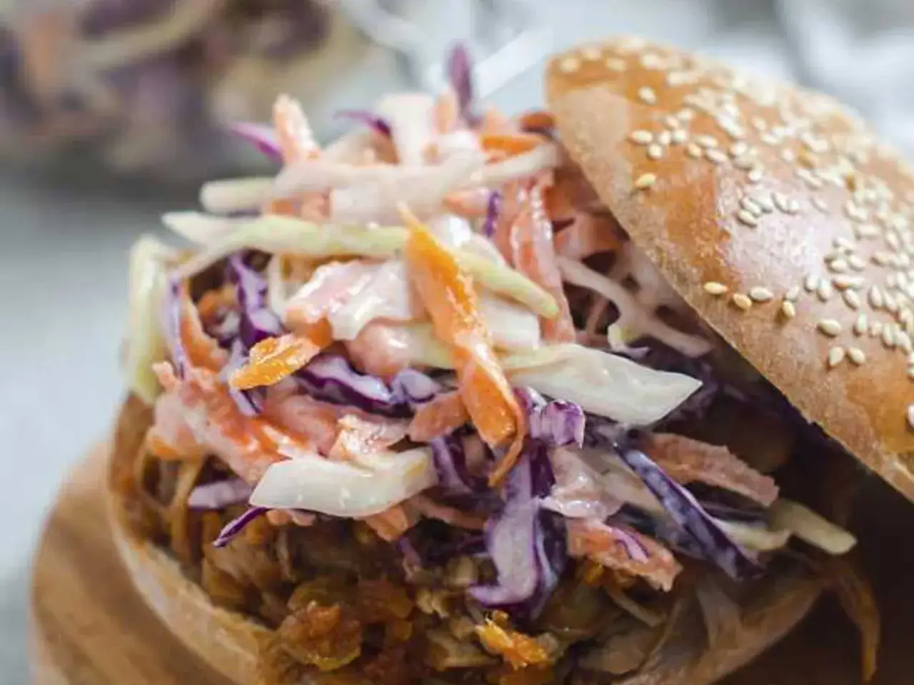 Saftiges pulled pork unter einem Berg aus cremigem Krautsalat auf einem Sesambr&ouml;tchen.