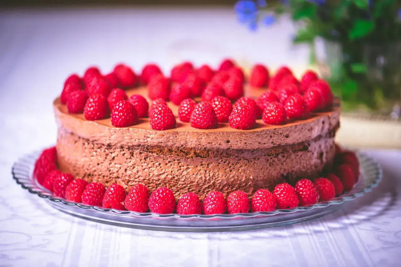 Eine k&ouml;stliche Mousse au Chocolat Torte, &uuml;ppig garniert mit frischen Himbeeren, wartet auf Genie&szlig;er.