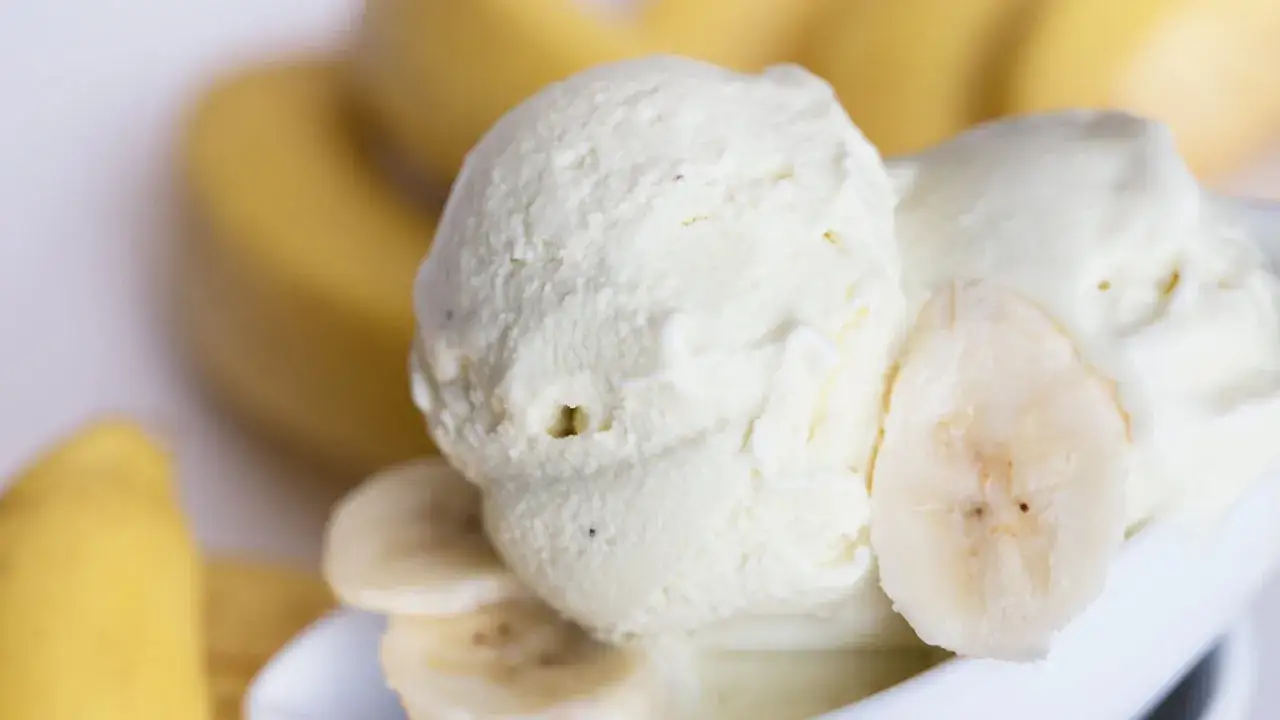Cremiges Bananeneis, gemacht mit gefrorenen Bananen, garniert mit Bananenscheiben.