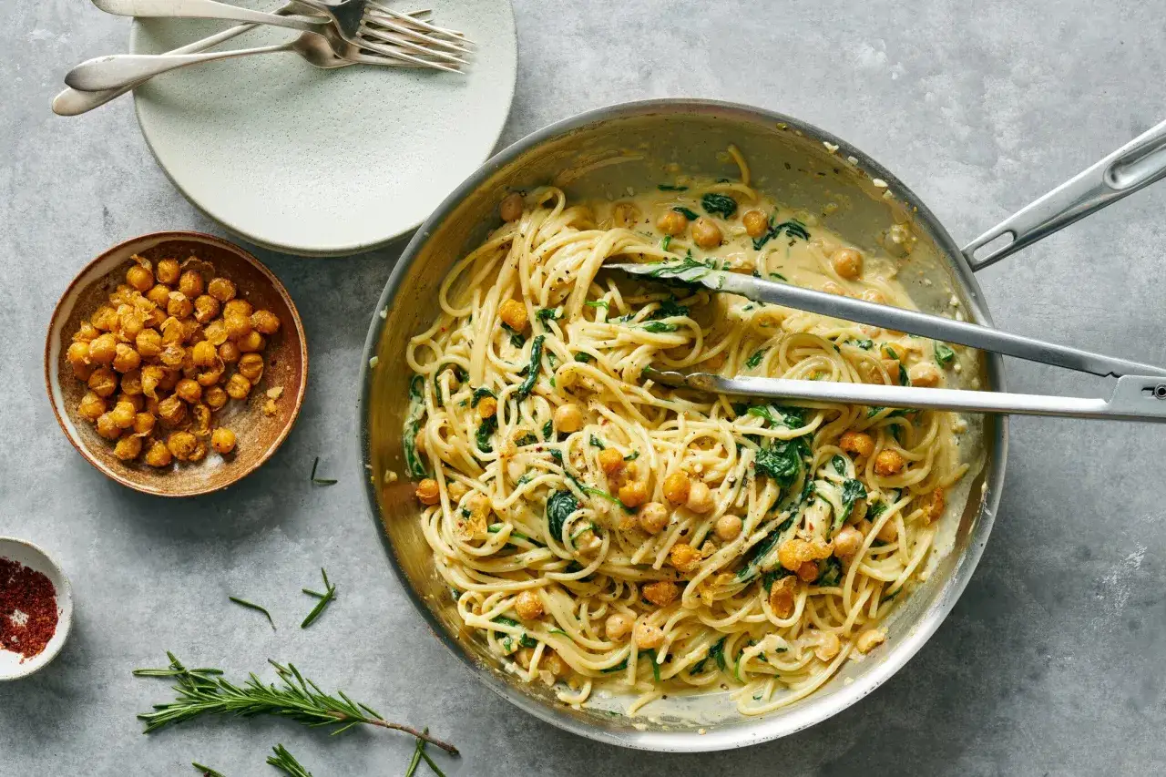 Cremige Pasta mit Spinat und Kichererbsen aus der Dose, daneben eine Schale ger&ouml;stete Kichererbsen. Leckere Rezepte mit Kichererbsen aus der Dose.