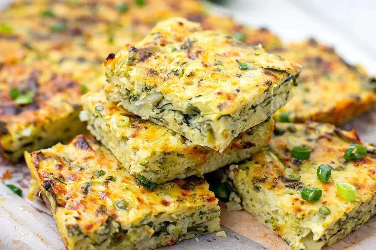 Gestapelte Stücke eines herzhaften Zucchinikuchens, garniert mit Frühlingszwiebeln. Perfekt für leichte zucchini rezepte.