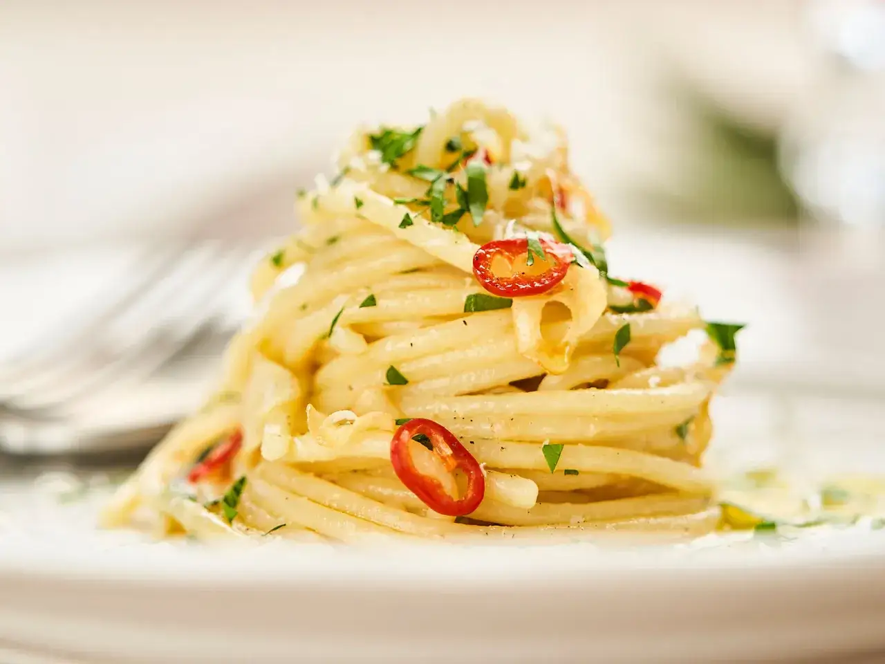 Ein Berg von Spaghetti Aglio e Olio, garniert mit frischer Petersilie und scharfen Chilischeiben, verlockt zum Genuss.