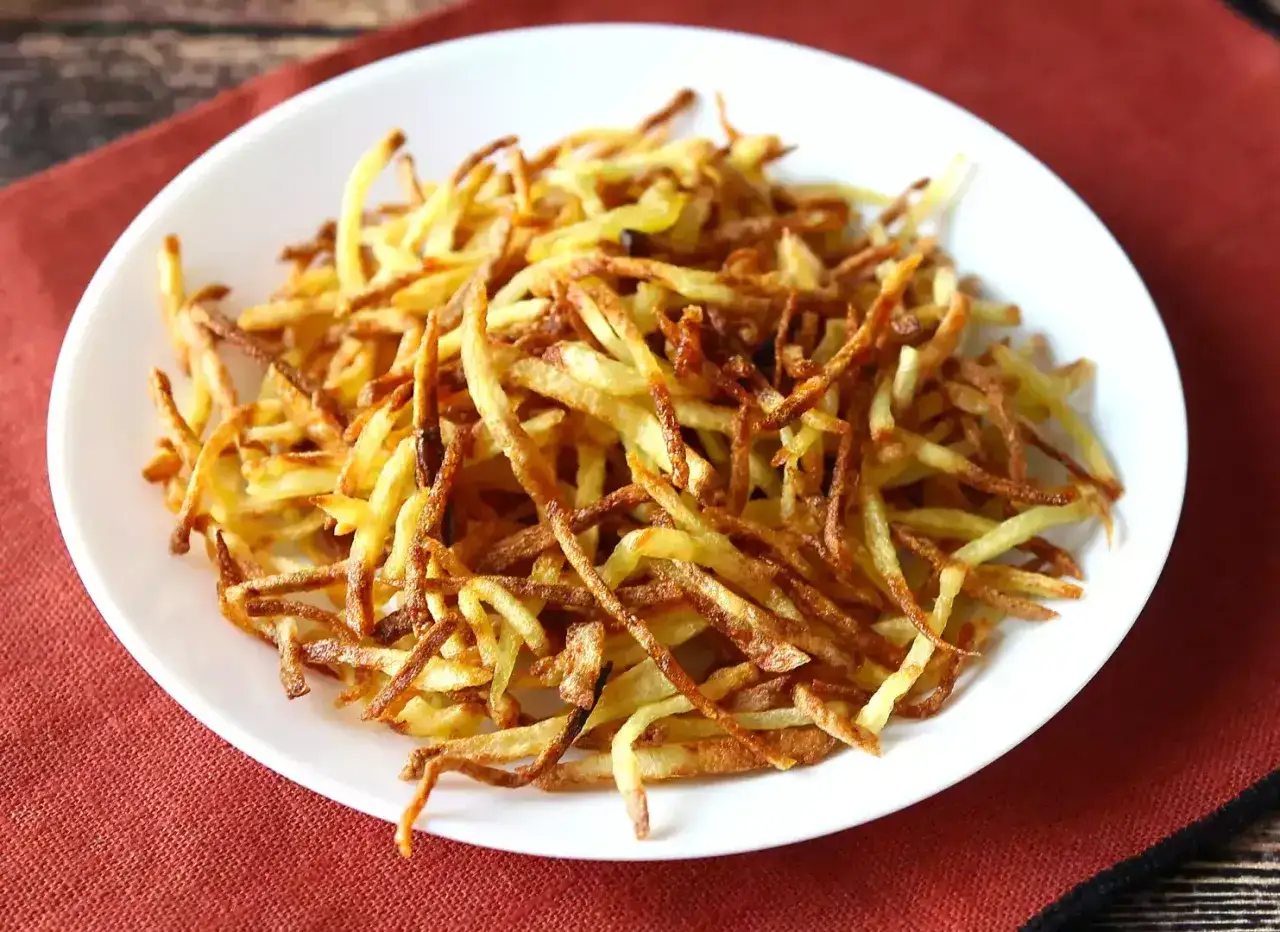 Knusprige Kartoffel-Chips aus dem Airfryer auf einem weißen Teller.
