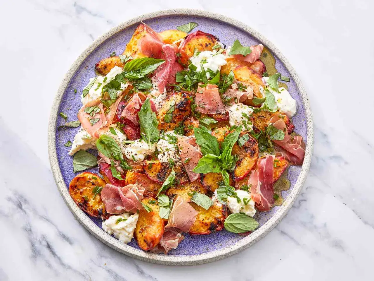 Gegrillte Pfirsiche mit Burrata, Prosciutto und Basilikum – eine köstliche Idee für warme Beilagen zum Salat.
