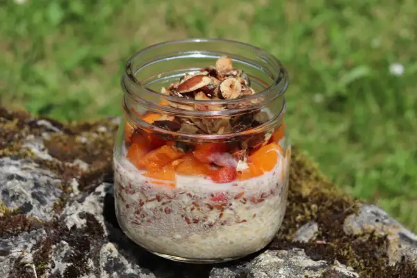 Veganes Overnight Oats im Glas mit Früchten und Nüssen, perfekt für einen gesunden Start in den Tag.