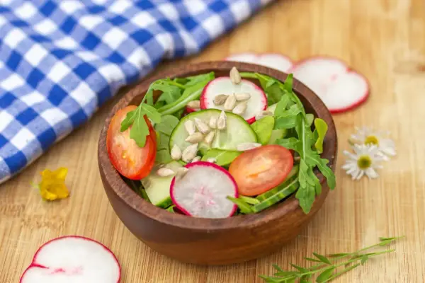 Frischer Salat mit Radieschen, Tomaten und Gurken, perfekt für leichte Radieschen Rezepte. Sonnenblumenkerne für den Crunch.