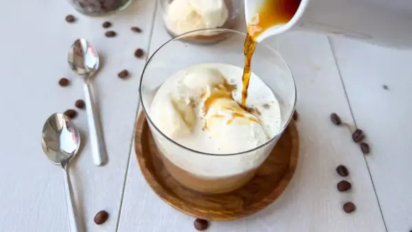 Ein heißer Espresso fließt über cremiges Vanilleeis. Ein perfekter Affogato Cafe, bereit zum Genießen.