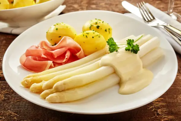 Spargel mit Sauce Hollandaise, kleinen Kartoffeln und Schinken. Eine Portion, die zeigt, wieviel Fisch pro Person auf den Teller passt, wenn man ihn durch Spargel ersetzt.
