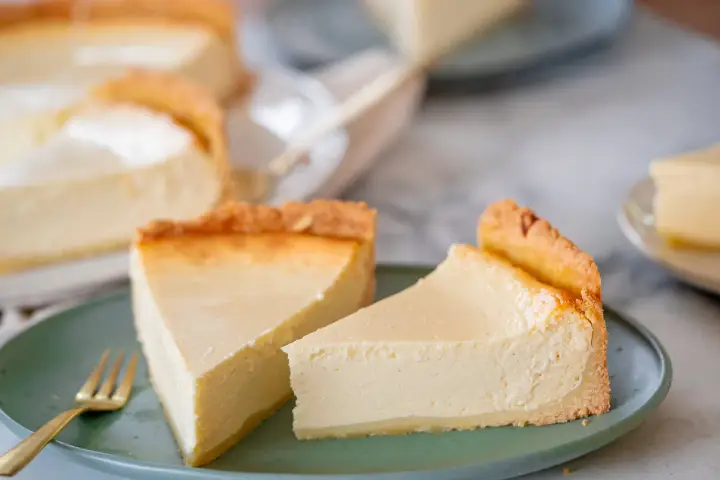 Zwei cremige Käsekuchenstücke auf einem grünen Teller, bereit zum Genießen. Perfekt für Ihre nächsten Kuchen Rezepte.