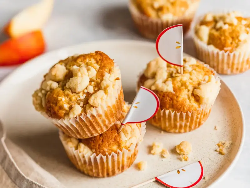Saftige apfelmuffins mit knusprigen Streuseln, dekoriert mit süßen Apfel-Fähnchen. Ein Genuss für jeden Apfelliebhaber!